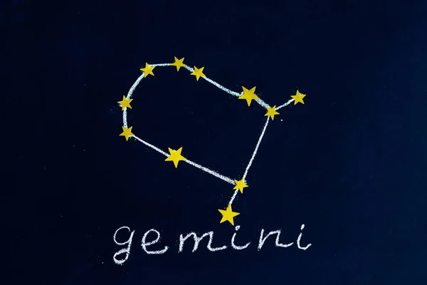 夜空のように見える黒板にチョークと金色の星で描かれた星座ジェミニ — ストック写真