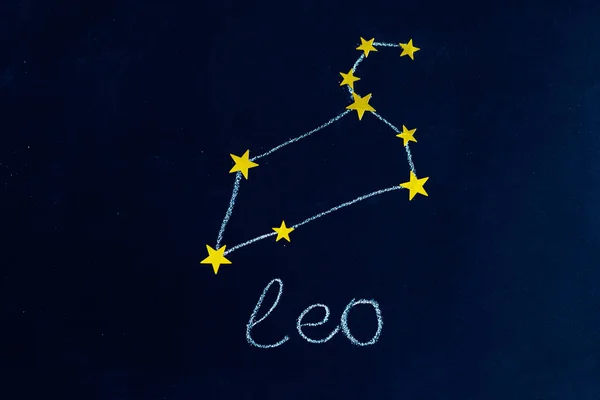 夜空のように見える黒板にチョークと金色の星で描かれた星座レオ — ストック写真