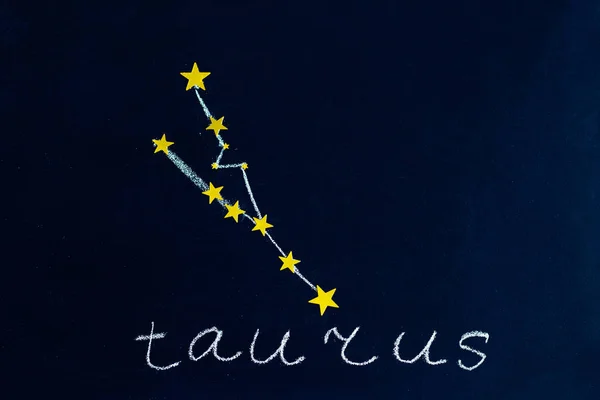 夜空のように見える黒板にチョークと金色の星で描かれた星座おうし座 — ストック写真