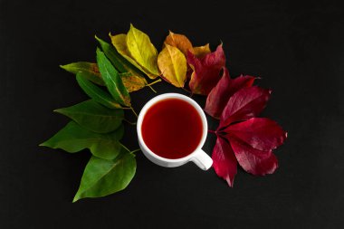 beyaz bir fincan ve siyah bir masa arka plan üzerinde sonbahar çok renkli yaprakları buket fincan sıcak içecek ile üst görünümü sonbahar duvar kağıdı