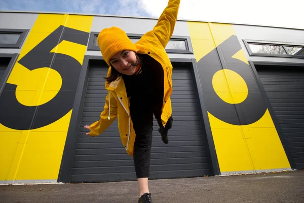 Счастливая Молодая Белая Женщина Жёлтой Шляпе Жёлтом Плаще Танцует Городской — стоковое фото