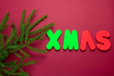 En üstteki görünüm Evergreen ağaç dalları kırmızı arkaplan üzerinde kelime xmas