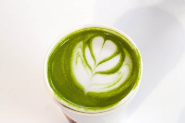 Üst görünümü kapatın. Beyaz arkaplanda eşleşen latte fincanı.