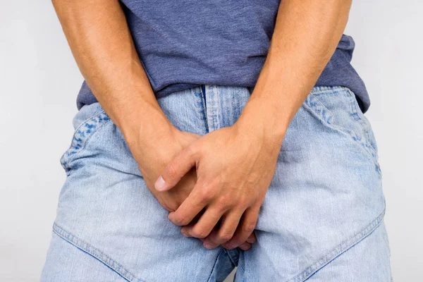 Man in pain covering his crotch,incontinence and sexually transmitted diseases concept — Stock Image Man Pain Covering His Crotch Incontinence Sexually Transmitted Diseases Concept Stock Photo