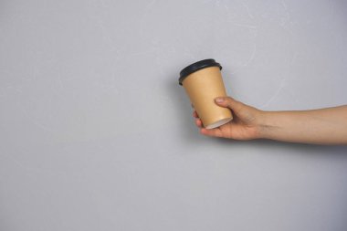 Beton duvar fotokopi alanına gitmek için kadın eli boş kahve tutuyor.