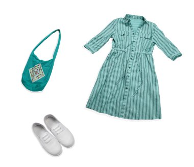 Üst kattaki düz manzaralı kadın yaz modası keten elbisesi, tekstil çantası ve beyaz arka planda izole edilmiş spor ayakkabıları.