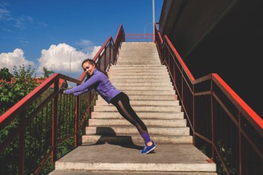 Sokakta şınav çeken genç bir kadın, şehir sporları konsepti.
