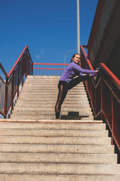 Молодая Атлетическая Девушка Стоит Ногой Перилах Лестницы Тренировки Городской Спортивной — стоковое фото