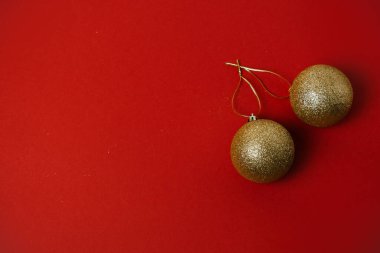 Kırmızı arkaplanda altın noel topları