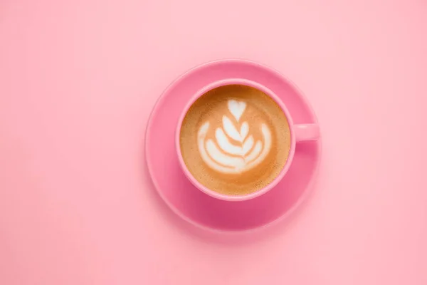 top view flat lay coffee with latte art pink cup on a soft pastel pink background