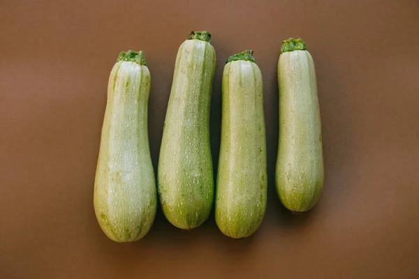 Vista Dall Alto Raccolta Quattro Zucchine Fondo Marrone — Foto Stock