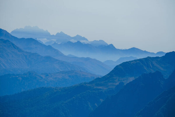 blurred abstract natural background with Caucasus Mountains in a morning blue mist