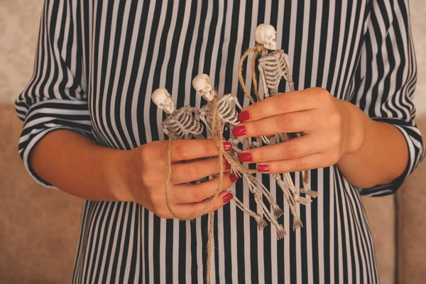 Close up female hands holding garland made of skeletons, Halloween preparation concept — Stock Image Close Female Hands Holding Garland Made Skeletons Halloween Preparation Concept Royalty Free Stock Images