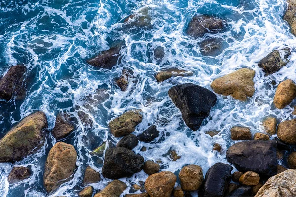 移动的海浪和地中海的蓝水接触岩石海滩 在海面上形成一些小的白色气泡 — 图库照片