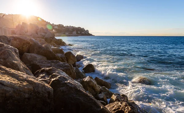 在太阳升起的时候 移动着的海浪和地中海的水接触着岩石海滩 使一些飞溅的水在空中飘扬 — 图库照片