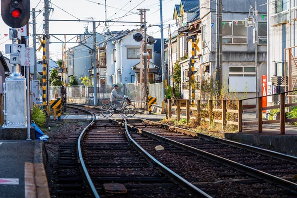 Japoński człowiek jeździ rowerem do Cross torów kolejowych — Zdjęcie stockowe