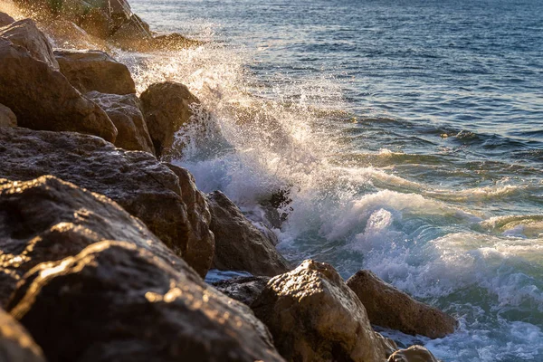 Разбрызгивание воды от прикосновения сильной волны к скалам — стоковое фото