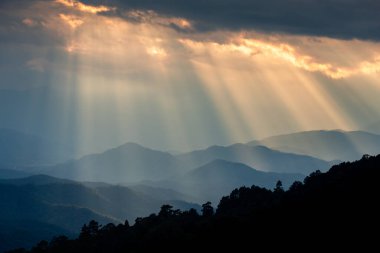 Güneş ışığı bulutlu gökyüzünden mavi dağlara, Huay Namdung, Chiangmai, Tayland.