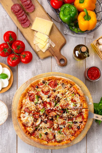 カラフルな野菜の食材 垂直オーバーヘッドトップビューで 木製のボードとテーブルに焼きたての最高のピザ — ストック写真