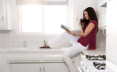 Evde Rahat rahat hafta sonu sabah, mutfakta kahve ile sabah güneş ışığında rahat bir kitap okuma