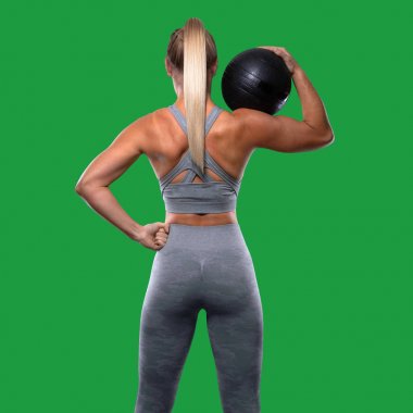 Güçlü kendine güvenen güç duruşu, ilaç topu ile kadın eğitmen, tonda kalça, üst vücut egzersiz, arkadan görkemli poz, arka, arka kaslar, popo, kollar, greenscreen