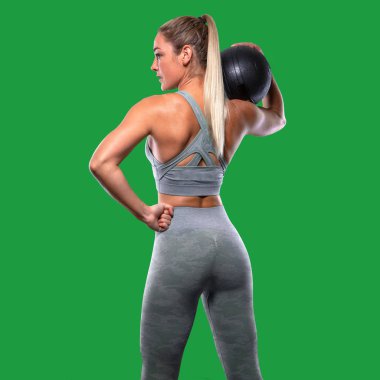 Güçlü kendine güvenen güç duruşu, ilaç topu ile kadın eğitmen, tonda kalça, üst vücut egzersiz, arkadan görkemli poz, arka, arka kaslar, popo, kollar, greenscreen