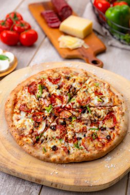 Tüm yüce pizza dikey havai üst görünümü, taze pişmiş sebze ve etler