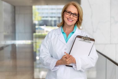 Sevimli sıcak ve samimi doktor doktor, sağlık profesyonel portre, hastane kliniğinde pano ile samimi gülümseyen