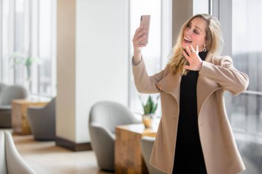 Güzel ve zarif iş kadını iş yerindeyken ailesiyle iletişim kurmak için görüntülü konuşma yapıyor.