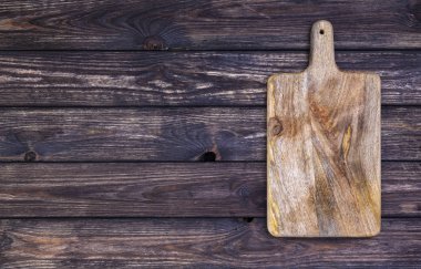 Eski kesme tahtası koyu ahşap masa üzerinde. Üstten görünüm. Kopya alanı