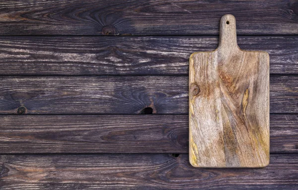 Eski kesme tahtası koyu ahşap masa üzerinde. Üstten görünüm. Kopya alanı