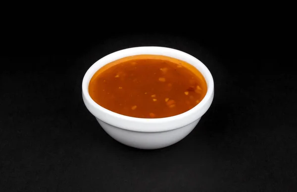 Sweet and sour sauce in bowl isolated on black background — Stock Photo, Image
