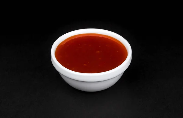 Salsa picante de chile en un tazón aislado sobre fondo negro —  Fotos de Stock