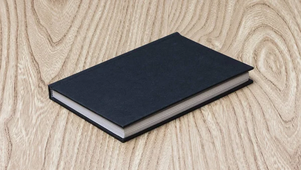 Black book on wooden table — Stock Photo, Image