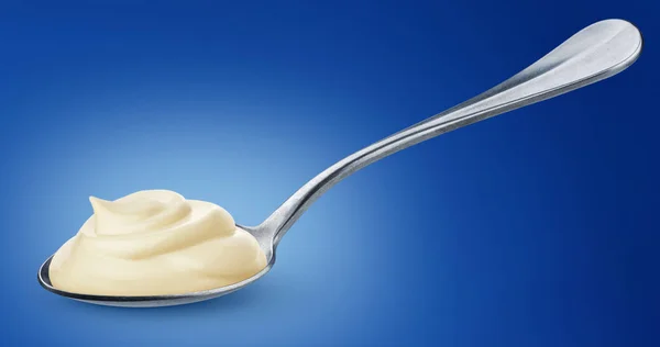 Sour cream in spoon isolated on blue background — Stock Photo, Image
