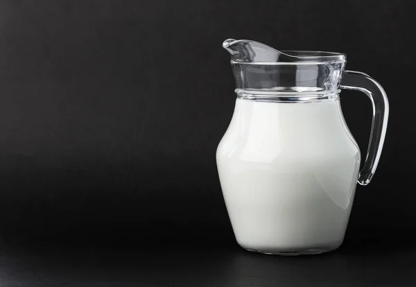 Jarra de vidrio de leche sobre fondo negro con espacio para copiar —  Fotos de Stock