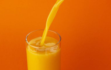 Portakal suyu cam, kopya alanı ile renk arka plan üzerinde izole içine dökme