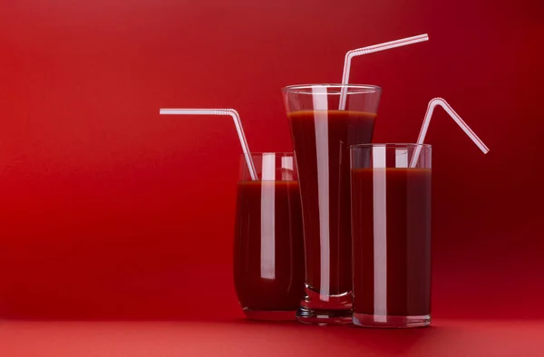Стакан томатного сока изолирован на красном фоне с копировальным пространством — стоковое фото
