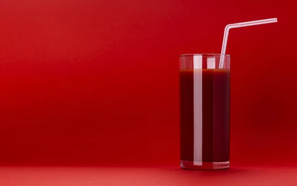 Стакан томатного сока изолирован на красном фоне — стоковое фото