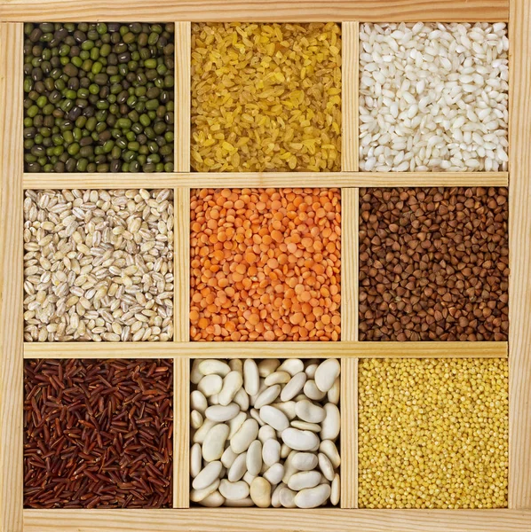 Groats in square wooden box, collection of cereals, beans and seeds, top view