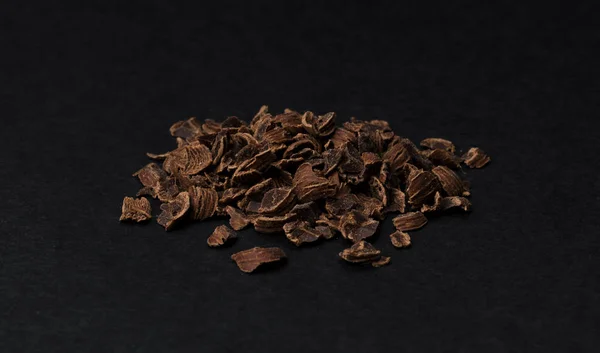 Grated chocolate. Heap of ground chocolate isolated on black background, closeup — Stock Photo, Image