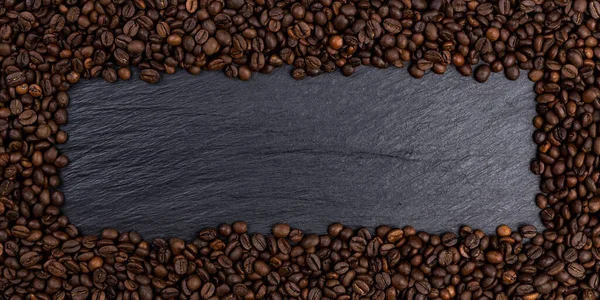 黒いテーブル、トップビューにローストコーヒー豆で作られたフレーム — ストック写真