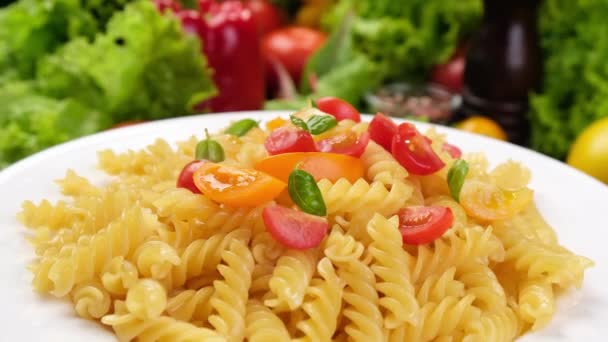 Pasta fusilli italiana con tomates y hojas de albahaca — Vídeos de Stock