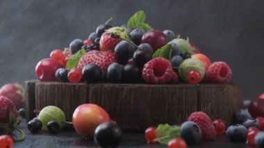 Kara arka planda yabani orman meyveleriyle su sisinin karışımı.