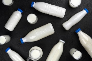 Süt ürünleri ambalajı, siyah arka planda süt ve krema şişeleri, üst görünüm