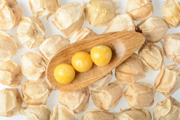 golden berries in wooden scoop, top view