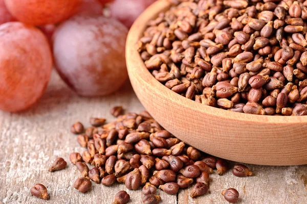 close up of dried grape seeds in wooden bowl