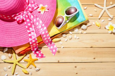 Plaj şapka, güneş gözlüğü, ahşap tahta üzerinde plaj havlusu
