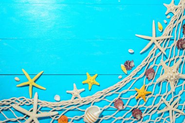 balık ağı ve kabukları mavi ahşap tahta üzerinde