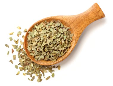 Beyaz arka plan üzerinde izole tahta kaşık kuru fesleğen yaprağı